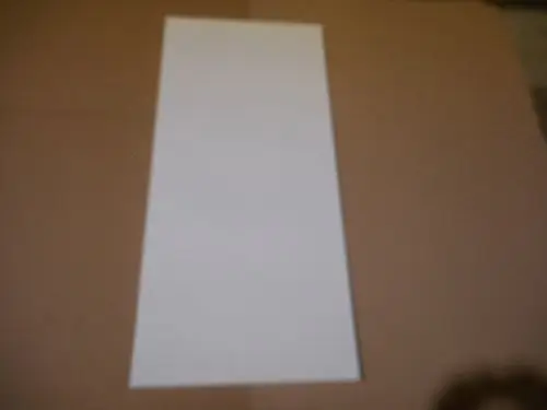 Weißes, rechteckiges Stück Papier auf einem braunen Untergrund. Es gibt keine weiteren erkennbaren Details oder Branding von Remeha auf dem Bild.